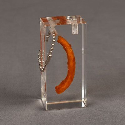 A french fry that has been cast inside acrylic for more than a year with amazing optical clarity.